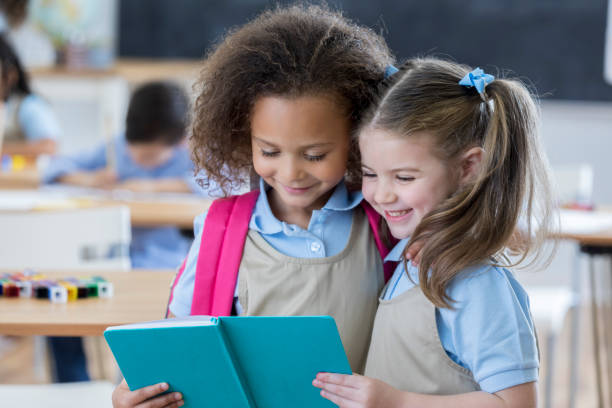 istock School friends read book at school 659542326