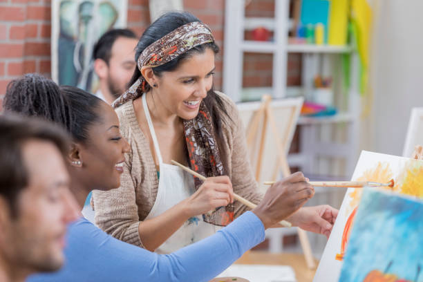 istock Mature artist teaches painting class 659542604