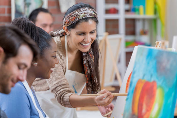 hispanic female artist teaches painting class - therapy people cheerful looking at camera imagens e fotografias de stock