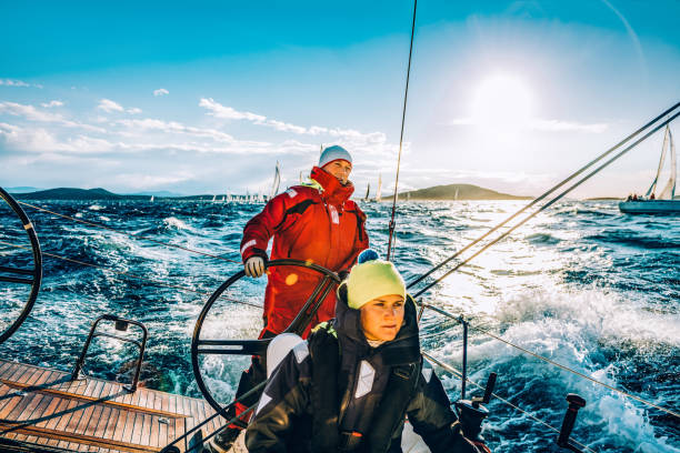 crew auf segelboot auf regatta zu segeln, auf sonnigen herbstmorgen - besatzung stock-fotos und bilder