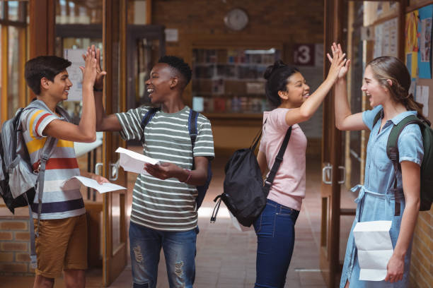 istock Happy classmates giving high five to each other in corridor 659578862