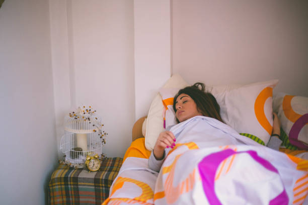 istock Young brunette woman sleeping in bed covered with quilt 659586814