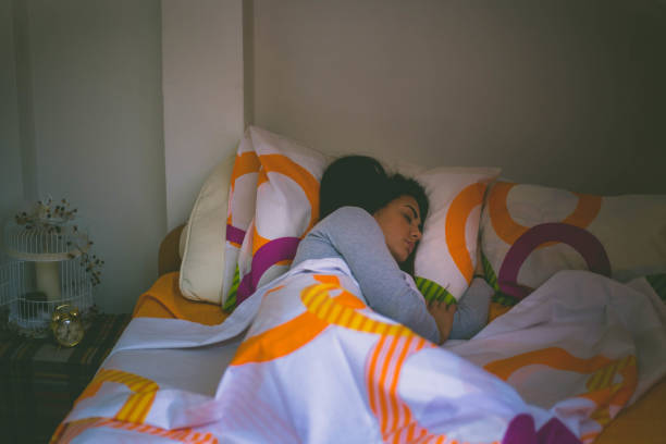 istock Young brunette woman sleeping in bed covered with quilt 659586914