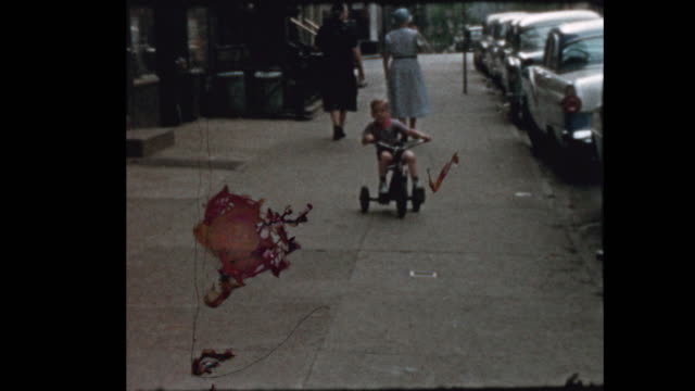 Little boy rides Tricycle down NYC street 1957