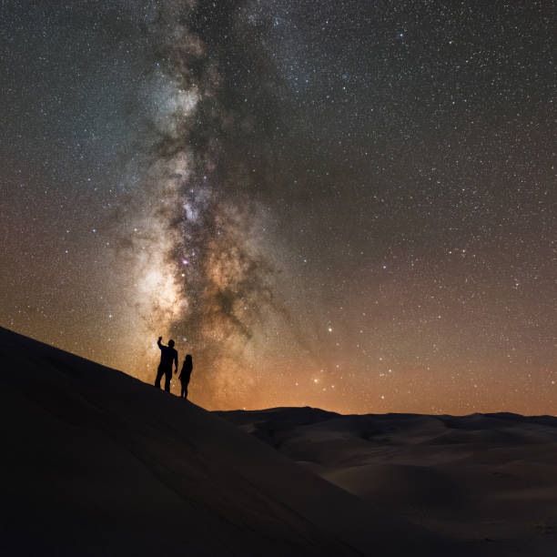Silhouette of people stargazing at the Milky Way Silhouette of a couple looking at the stars in Great Sand Dunes National Park, Colorado. astrophotography stock pictures, royalty-free photos & images