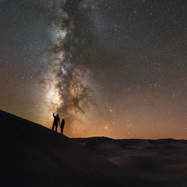 Silhouette of a couple looking at the stars in Great Sand Dunes National Park, Colorado.