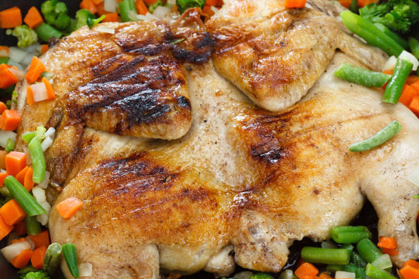 istock Whole grilled chicken with vegetables in a frying pan 659634976