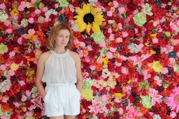 istock Woman on front of flower`s wall. 659635014