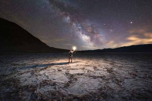 Midnight Explorer illuminating Badwater Basin at night Badwater basin under the Milky Way Galaxy death valley desert photos stock pictures, royalty-free photos & images