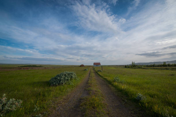 Dirt road leading to a house and hanger.