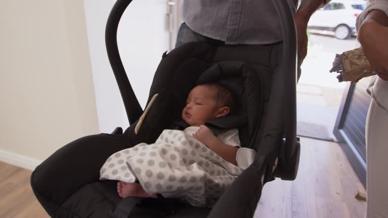 Parents Arriving Home With Newborn Baby In Car Seat