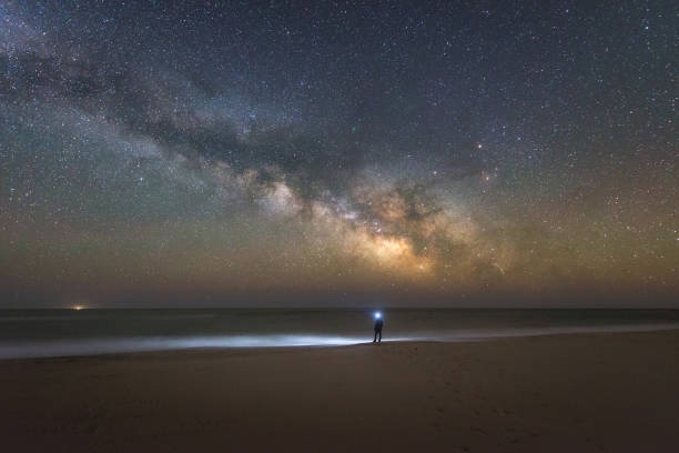 istock Man watching the milky way rise over the beach 659653454