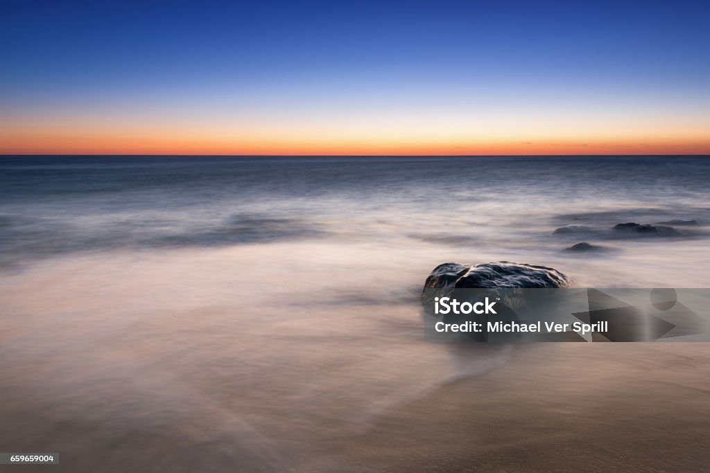 Misty rock seascape sunrise Sunrise from Sandy Hook beach in New Jersey. Atlantic Ocean Stock Photo