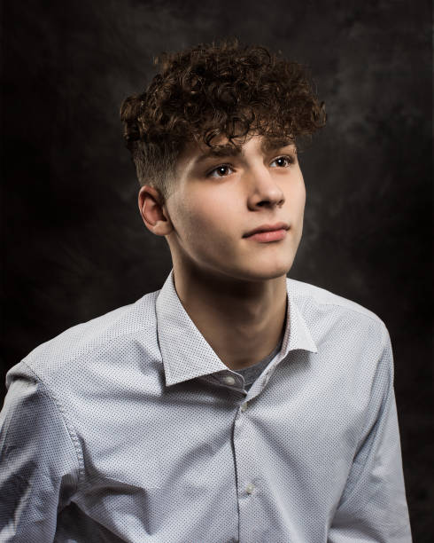 White Teenage Boy Studio Portrait One well dressed long haired male model teenager posing for yearbook senior picture school picture stock pictures, royalty-free photos & images