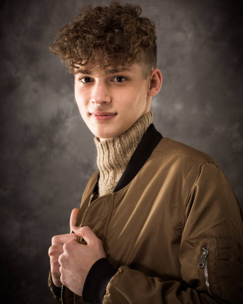 One well dressed long haired male model teenager posing for yearbook senior picture