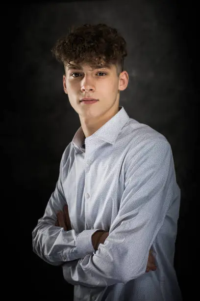 One well dressed long haired male model teenager posing for yearbook senior picture