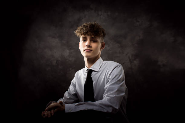 White Teenage Boy Studio Portrait One well dressed long haired male model teenager posing for yearbook senior picture school picture stock pictures, royalty-free photos & images