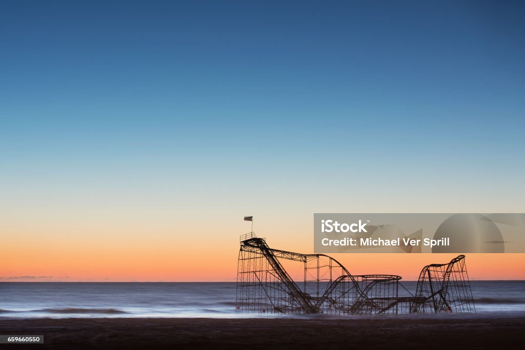 Sunrise behind the iconic Jet Star roller coaster after hurricane Sandy The aftermath of Hurricane Sandy left the star jet roller coaster in the ocean. Hurricane Sandy Stock Photo