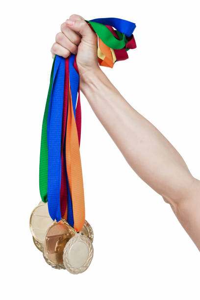 close up of a hand holding medals - effort gold indoors studio shot imagens e fotografias de stock