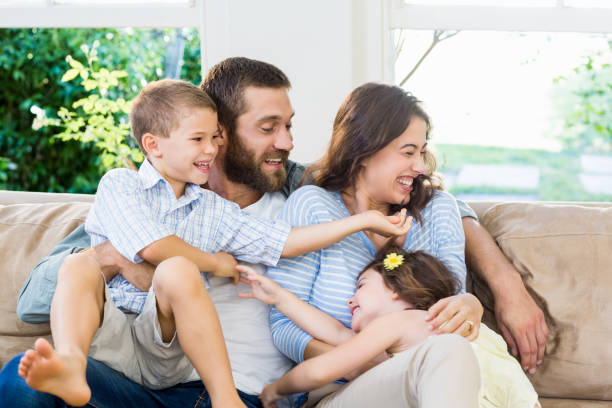 istock Parents and kids sitting on sofa and having fun 659710200