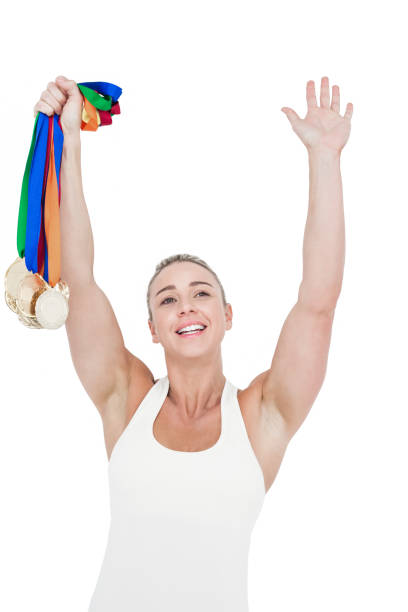 feliz mujer atleta medallas de retención - effort gold indoors studio shot fotografías e imágenes de stock
