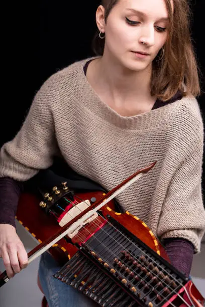 Photo of Woman playing a nyckelharpa musical instrument