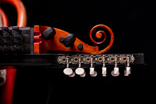 nyckelharpa's scroll, headstock and pegbox details, concept of folk, baroque and classical music played with handcrafted ancient string musical instruments