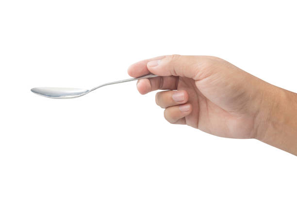istock hand holding metal spoon isolated on white background 659772088