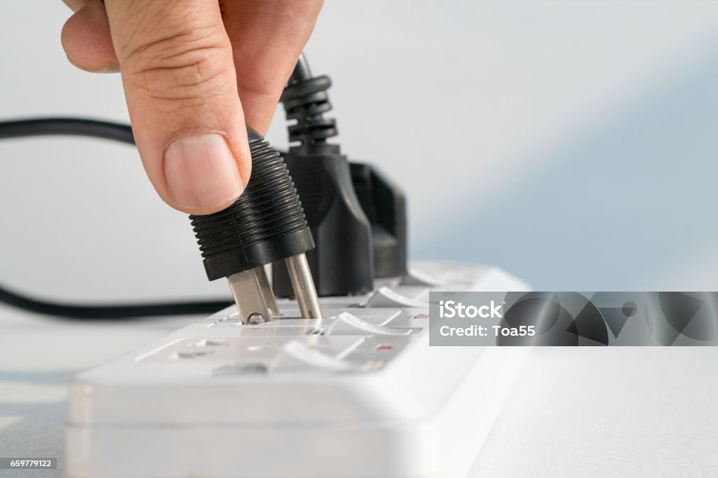 Close up Elderly hand plugging into electrical outlet Electrical Outlet Stock Photo