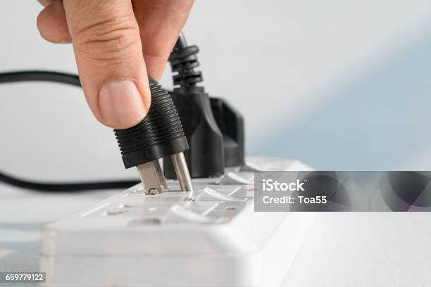 Close Up Elderly Hand Plugging Into Electrical Outlet Stock Photo - Download Image Now