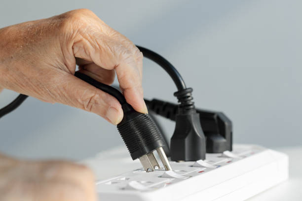 Close up Elderly hand plugging into electrical outlet Close up Elderly hand plugging into electrical outlet trailblazing stock pictures, royalty-free photos & images