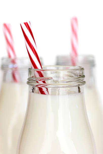 istock Bottles of Milk with Red Striped Straws over White 659791978