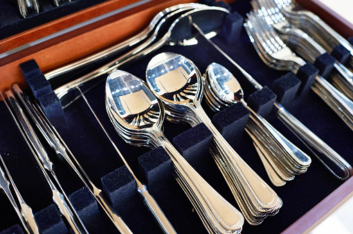 Cutlery forks, spoons and knives on a dark blue velvet background