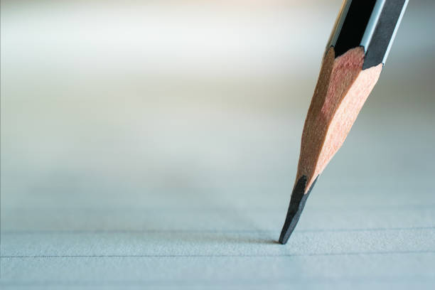 istock close up of pencil writing on paper with light. 659810004