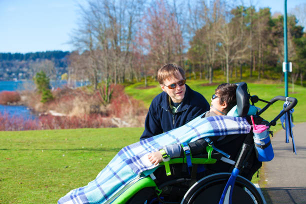 istock Disabled boy in wheelchair talking with father at lakeside park 659830258