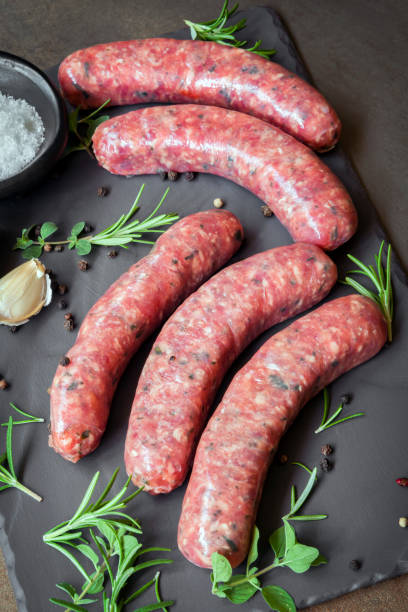 istock Raw Sausages with Herbs and Spices on Slate 659839110