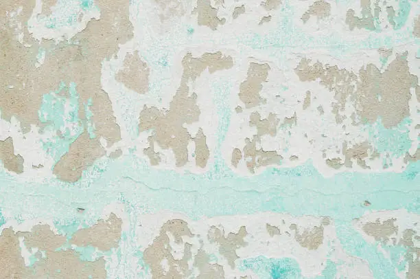Closeup pale color and peeling of painted green cement wall textured background