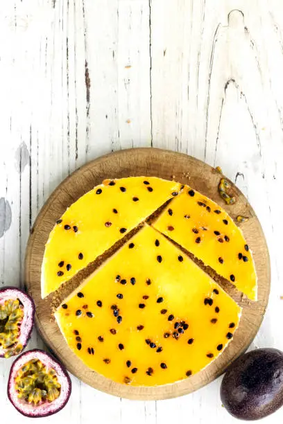 Passionfruit cheesecake, top view on white grunge timber.  With fresh fruit.