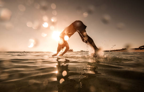 istock Man diving into the sea during summer day at sunset. 659936564