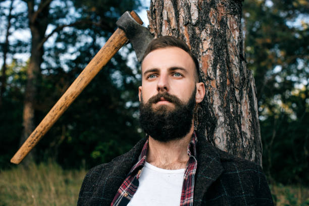 istock Portrait brutal bearded hipster man in the forest with ax 659987932
