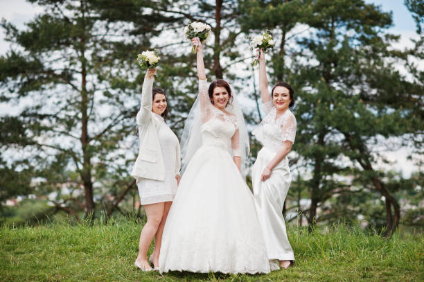 istock Pretty bride with bridesmaids on white dresses with bouquets on hands at wedding day. 659988980