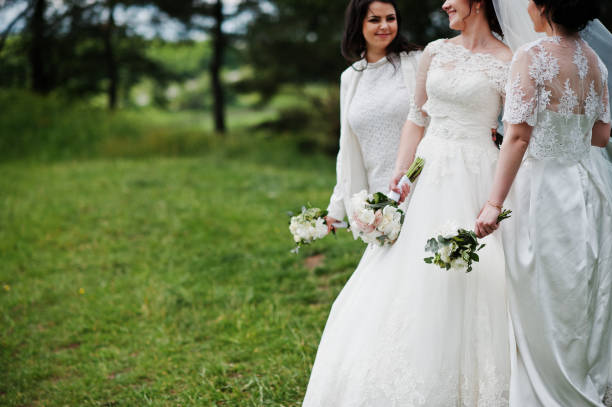 istock Pretty bride with bridesmaids on white dresses with bouquets on hands at wedding day. 659989146