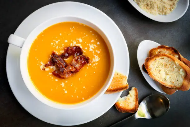 Photo of Pumpkin Soup with Bacon Parmesan and Garlic Bread Top View