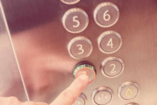 istock Finger presses on first floor in modern metal elevator business building 660005730