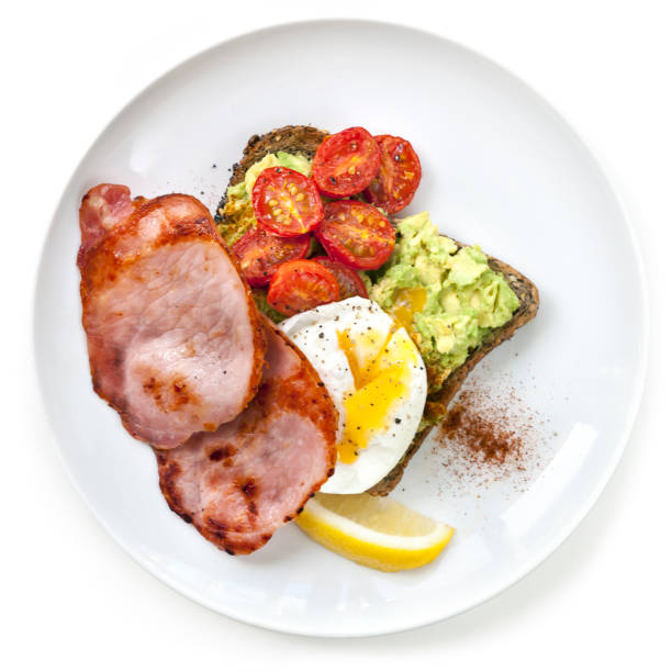 チェリー トマトとアボカド トースト半熟卵とベーコンのトップ ビュー - breakfast bacon eggs toast ストックフォトと画像
