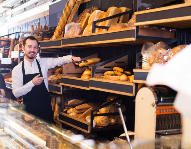 istock Seller offering fresh loaf of bread 660041808