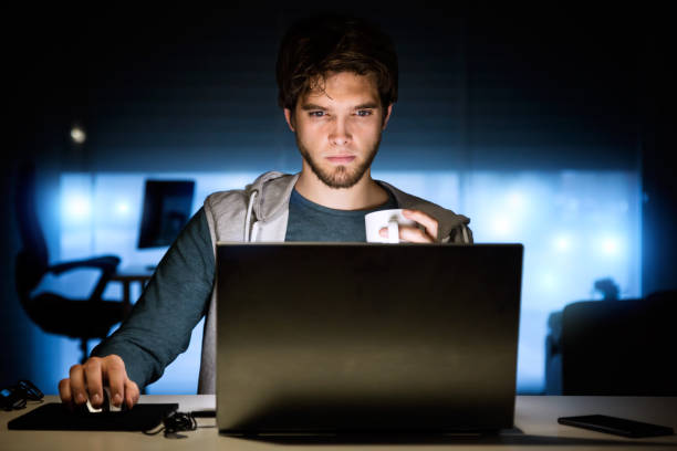 istock Handsome young man working with laptop in his office at night. 660043668