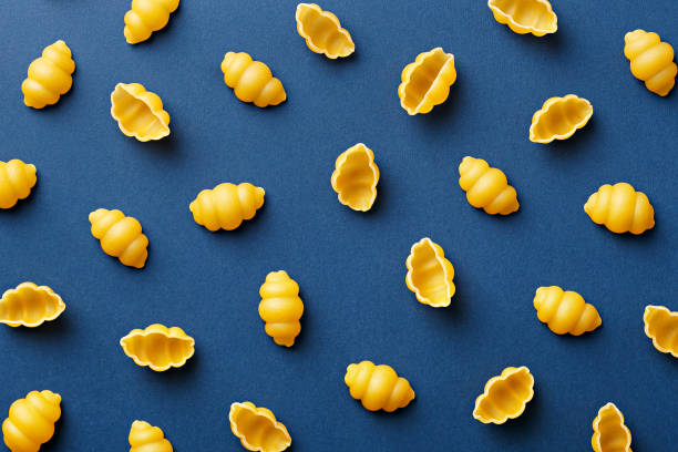 Gnocchi pasta pattern on a blue background. Repetition concept. Top view