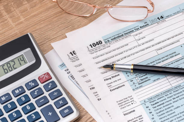 istock 2017 year tax form 1040 with calculator and pen. 660088584