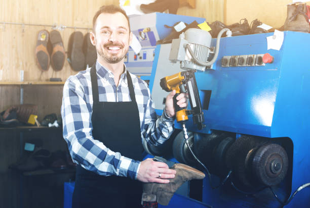 istock male worker fixing failed shoes in shoe repair workshop 660100596